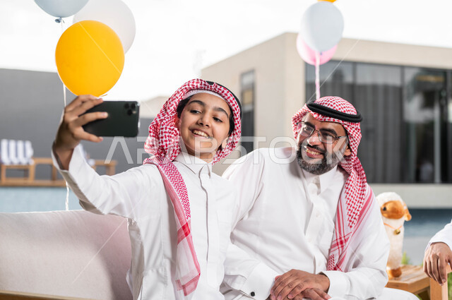 التقاط صور السيلفي عبر الجوال, التجمعات والزيارات العائلية في عيد الاضحى المبارك, فتى عربي خليجي سعودي يرتدي الزي السعودي التقليدي, الاحتفال في العيد مع الابناء و الاحفاد في الشاليهات والمنتجعات في ايام العيد السعيد في السعوديه, أعياد ومناسبات اسلامية