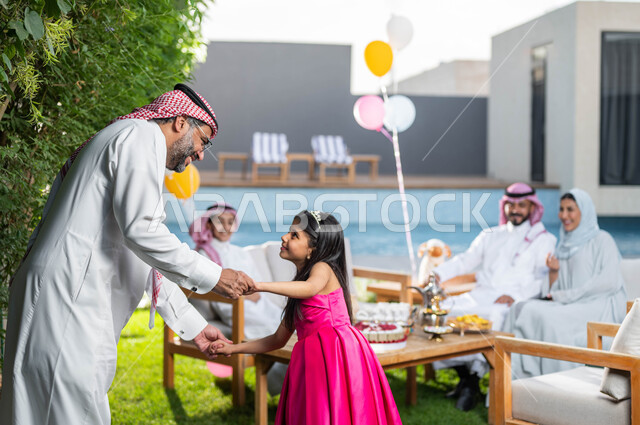 اللعب مع الاحفاد في احدى الشاليهات الفاخره ,رجل كبير السن عربي خليجي سعودي يرتدي الزي التقليدي السعودي , اجتماع العائله والاحتفال مع الأطفال في العيد السعيد ، انشطه ترفيهيه في الاعياد  والمناسبات العائليه