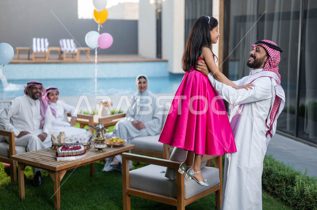 Gestures indicating joy and happiness, spending pleasant times with children in chalets and resorts during the happy Eid days in Saudi Arabia, family visits and gatherings, a Saudi Arabian Gulf father carrying his daughter and celebrating Eid al-Adha, Isl