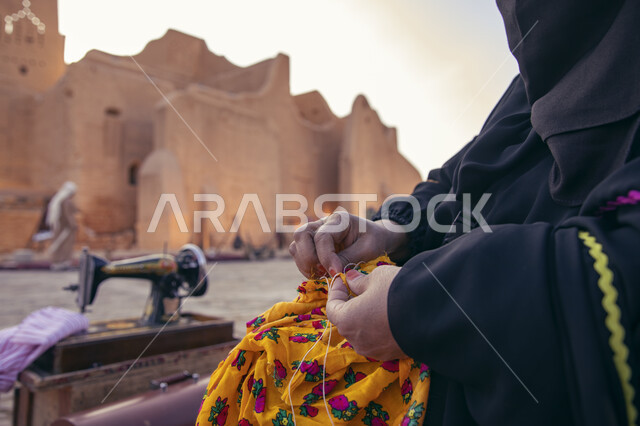 معالم تراثية اثرية شعبية مشهورة ,إمرأة عربية خليجية سعودية تقوم بالحياكة على الاقمشة ,احتفالات افتتاح مطل ومنتزه البجيري في الدرعية في مدينة الرياض ،مشروع تطوير الدرعيه التاريخيه .