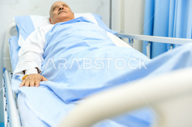 رجل كبير بالسن عربي خليجي سعودي مريض مستلقي على سرير المستشفى، تلقى العلاج و العناية في المستشفى ،اجراء عمليه جراحية ، مستشفى خاص بكبار السن، مفهوم الطب والرعاية الصحية