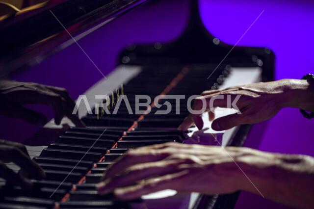 العزف على البيانو في موسم تنوين للأنشطة الترفيهية و الثقافية و التعليمية، صورة مقربة لايدي شاب سعودي يعزف على آلة البيانو الموسيقية,  العزف و الانشطة الترفيهية في مركز الملك عبد العزيز الثقافي العالمي في مدينة الظهران في المملكة العربية السعودية.