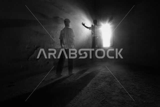 صورة بالاسود والأبيض لولد يقف في داخل غرفه مظلمه, شاب داخل نفق مظلم,  مفهوم الوحده والعزله, التشتت والضياع الفكري في مرحلة المراهقه, هواجس النفس البشريه, سيلوليت، النهاية المشرقة بعد طريق مظلم. 