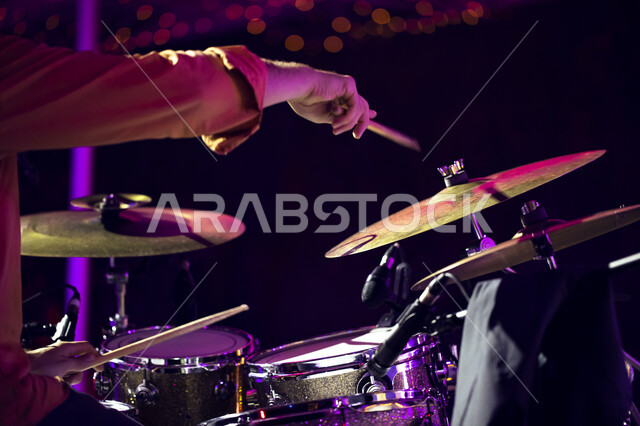 Drumming using percussion instruments, a close-up of the hands of a Saudi Arabian Gulf man playing a drum during the Tanween season for educational, recreational and cultural activities, presenting musical and theatrical arts at the King Abdulaziz Cultura
