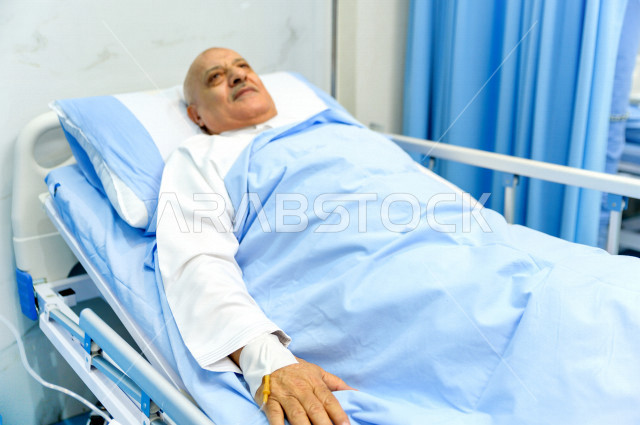 رجل كبير بالسن عربي خليجي سعودي مريض مستلقي على سرير المستشفى، تلقى العلاج و العناية في المستشفى ،اجراء عمليه جراحية ، مستشفى خاص بكبار السن، مفهوم الطب والرعاية الصحية