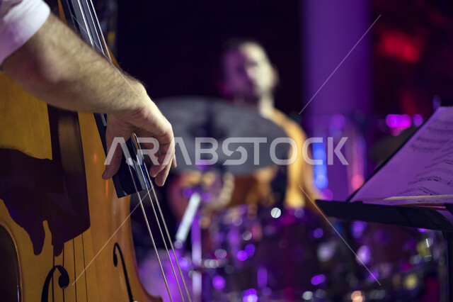 Playing the violin during the Tanween season for entertainment, cultural and educational activities. A close-up of the hands of a young Saudi man playing the stringed violin. Playing and entertainment activities at the King Abdulaziz Center for World Cult