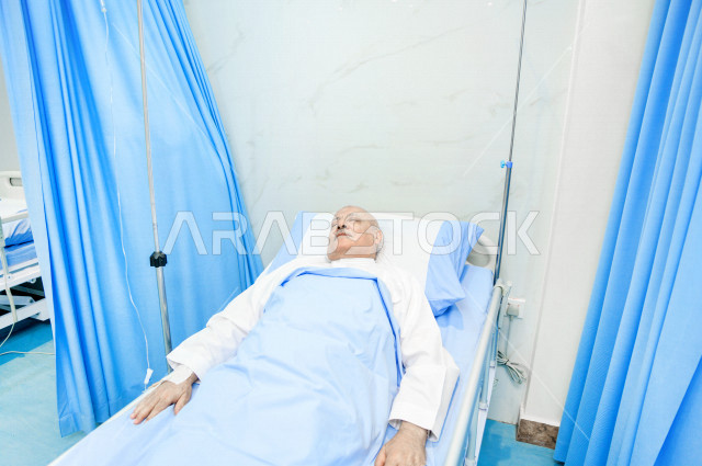 رجل كبير بالسن عربي خليجي سعودي مريض مستلقي على سرير المستشفى، تلقى العلاج و العناية في المستشفى ،اجراء عمليه جراحية ، مستشفى خاص بكبار السن، مفهوم الطب والرعاية الصحية