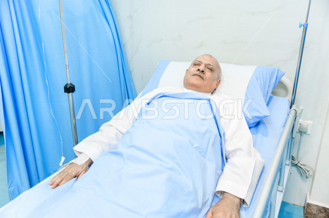 رجل كبير بالسن عربي خليجي سعودي مريض مستلقي على سرير المستشفى، تلقى العلاج و العناية في المستشفى ،اجراء عمليه جراحية ، مستشفى خاص بكبار السن، مفهوم الطب والرعاية الصحية