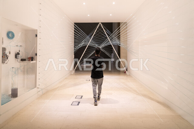 رجل يستمتع بالنظر لمتحف اثراء من الداخل في مركز الملك عبد العزيز الثقافي في مدينة الظهران في المملكة العربية السعودية,  موسم تنوين للأنشطة الترفيهية و الثقافية و التعليمية, منارة ثقافية ومعالم سياحية مشهورة.