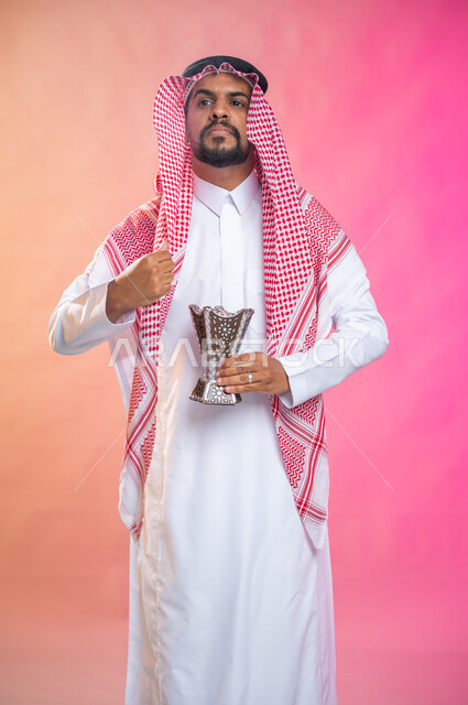 Perfumed with incense and oud, a portrait of a Saudi Arabian Gulf man wearing the traditional Saudi thobe and shemagh, wearing perfume with an incense burner (the incense burner), the use of oud wood on occasions and holidays, Saudi customs and traditions