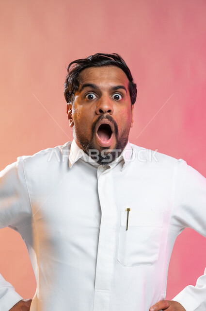 إيماءات وجه ويدين تدل على الدهشه و الذهول, بورتريه لرجل عربي خليجي سعودي يضع يديه على وسطه,  التعجب و التفاجؤ من شيئ ما, الصدمه و الإستغراب, خلفيه ملونة.