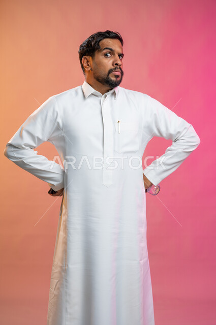 ايماءات الغضب و الاستياء و عدم الرضا, بورتريه لشاب عربي خليجي سعودي يرتدي الزي السعودي التقليدي يقف بإستقامة, الاعتراض على شيء ما, نظرات توبيخ و تأنيب, خلفية ملونة.