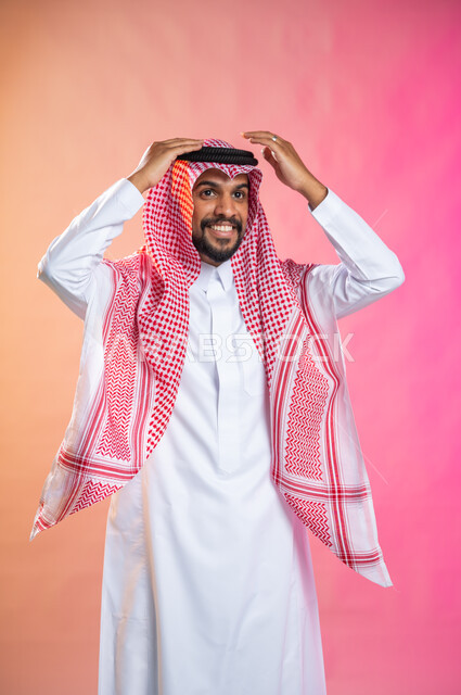 الاهتمام بالمظهر الخارجي و الشياكه و  الأناقة, شاب سعودي عربي خليجي يرتدي الثوب و الشماغ الأحمر, التزين و التجمل و الترتيب, الاستعداد للخروج, خطوات لبس الشماغ السعودي التقليدي, خلفية ملونة.