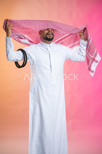 خطوات لبس الشماغ السعودي التقليدي,   الاستعداد للخروج, التزين و التجمل و الترتيب, شاب سعودي عربي خليجي يرتدي الثوب و الشماغ الأحمر, الاهتمام بالمظهر الخارجي و الشياكه و  الأناقة, خلفية ملونة.