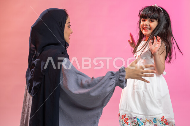 ايماءات طفلة تدل على الاشتياق و الحب, قضاء أوقات عائلية ممتعة, مشاعر الأمومة و العطف، بورتريه لفتاة عربية خليجية سعودية تركض بتلهف لتعانق والدتها, عناق الأبناء،  مفهوم الأسرة السعيدة،مشاعر الأمومة و العطف،   خلفية ملونة.