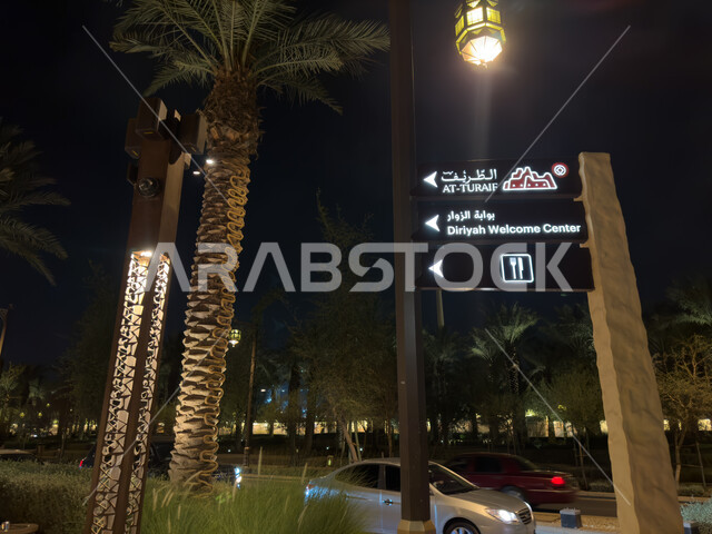 لوحة ارشادية لبوابة الزوار  في الدرعية في الرياض في الممكلة العربية السعودية, زراعة النباتات و أشجار النخيل,  حركة مرور السيارات في طريق مطل البجيري, اماكن سياحيه تاريخيه اثريه مشهوره, مشروع تطوير الدرعية التاريخيه, معالم السعودية التاريخية