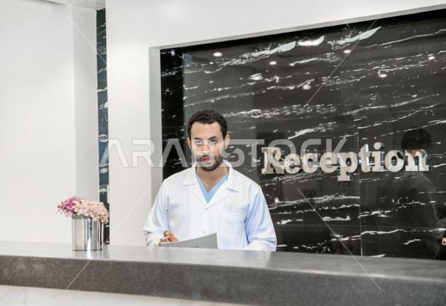 A Saudi Arabian Gulf receptionist at the hospital reception, follow-up and fill in patient data, complete admission procedures to the hospital, provide health care