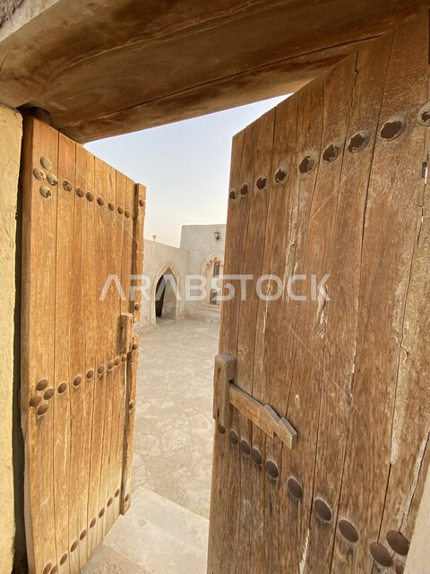 الفن المعماري الاسلامي من الطراز القديم ,صورة مقربة لباب المسجد الخشبي الكبير, مسجد قديم في منطقة الأحساء بالمملكة العربية السعودية ,  اسلاميات وعبادة, جامع عتيق من الطين و الحجر الابيض, معالم اثرية دينية تاريخية .