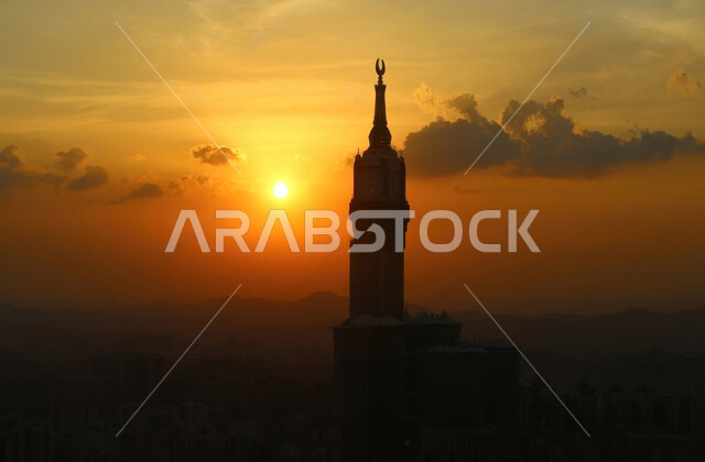 صورة ظليه لبرج الساعة في مكة المكرمة في المملكة العربية السعودية وقت غروب الشمس ، الفن الهندسي المعماري ، مبنى برج ساعة مكة الملكي في المسجد الحرام ،أبراج وناطحات السحاب, معالم اسلامية دينية مقدسة .