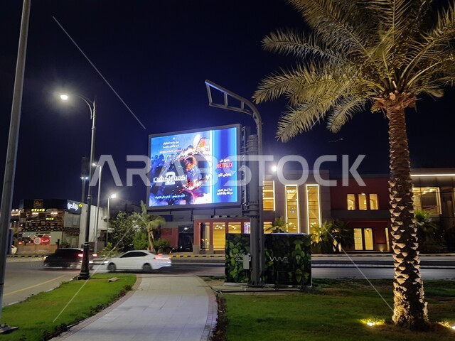 شاشات اعلانية مضيئة في طريق كورنيش جدة في المملكة العربية السعودية, زراعة النباتات و أشجار النخيل, حركة سير السيارات في الطرق و الشوارع ليلا, معالم سياحية مشهورة في مدينة جدة 