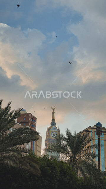 Sacred Islamic religious landmarks, the clock tower in Makkah Al-Mukarramah in the Kingdom of Saudi Arabia among palm trees, architectural engineering art, the Makkah Royal Clock Tower building in the Grand Mosque, towers and skyscrapers, nature backgroun