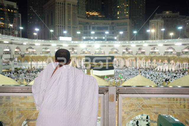 صورة من الخلف لحاج يرتدي ملابس الاحرام، الكعبة المشرفة في مكة المكرمة في المملكة العربية السعودية، حجاج بيت الله الحرام في ساحات الحرم المكي الشريف، أداء مناسك الحج والعمرة، الطواف حول الكعبة المشرفة، موسم الحج 2023، أماكن اسلامية مقدسة