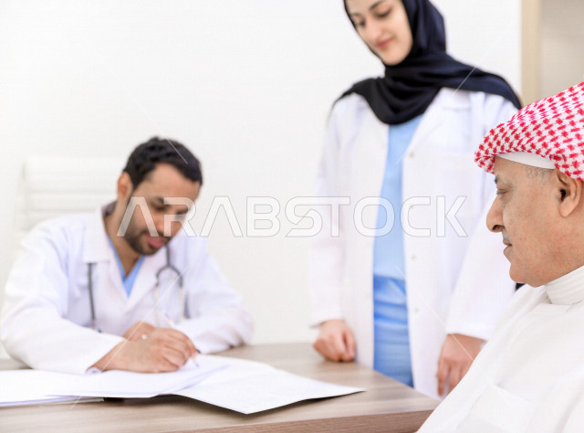 رجل عربي خليجي سعودي في موعد مع اطباء استشاريين سعوديين ، طبيب اخصائي في المستشفى يقدم الاستشارات الطبية والخدمات الصحية  ، مفهوم الطب والرعاية الصحية