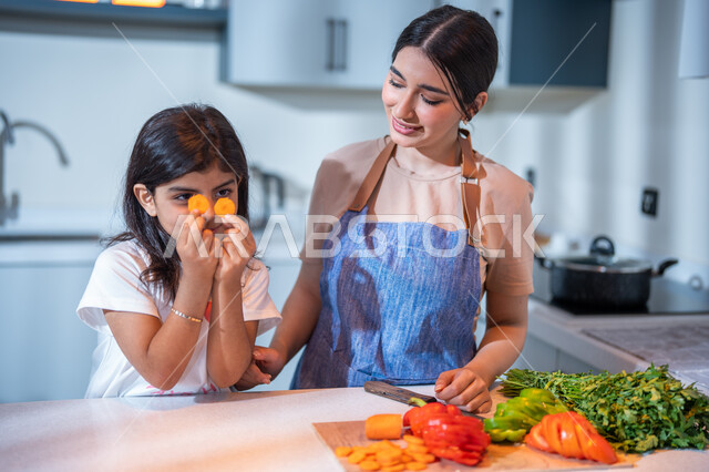 قضاء أوقات ممتعة مع الأبناء, سلطة الخضار اللذيذة الطازجة ، فنون الطبخ والتقطيع, ايماءات تدل على السعادة, أم عربية خليجية سعودية تقوم بتعليم ابنتها الطبخ، مفهوم النظام الغذائي، غذاء صحي ومفيد، إعداد و تحضير الطعام، وصفات الطعام الشهية