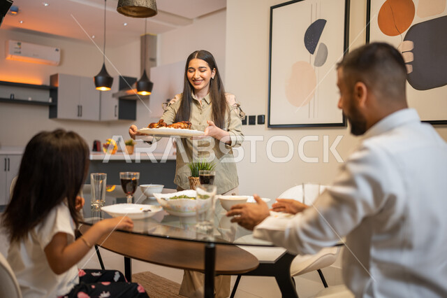 أجواء عائلية مليئة بالحب ,اعداد وتحضير وجبة الغداء، ايماءات وتعابير تدل على السعادة, أجواء عائلية سعيدة, عائلة عربية خليجية سعودية تجلس على مائدة الطعام المليئة بأصناف متنوعة وشهية, قضاء أوقات ممتعة مع العائلة