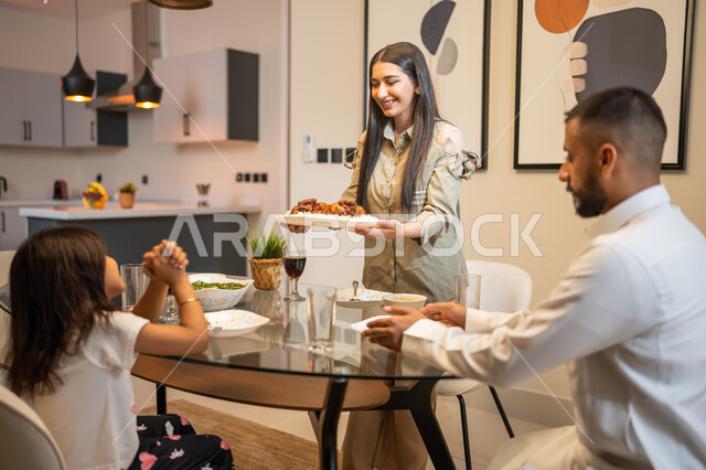 تحضير وتقديم وجبة الغداء، ايماءات وتعابير تدل على السعادة, أجواء عائلية سعيدة, عائلة عربية خليجية سعودية تجلس على مائدة الطعام المليئة بأصناف متنوعة وشهية, قضاء أوقات ممتعة مع العائلة