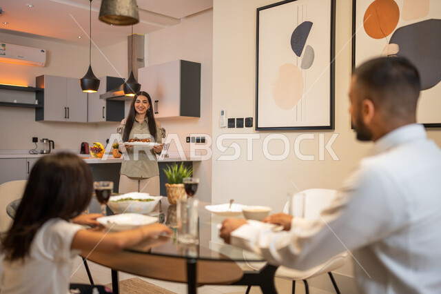 اعداد وتحضير وجبة الغداء، ايماءات وتعابير تدل على السعادة, أجواء عائلية سعيدة, عائلة عربية خليجية سعودية تجلس على مائدة الطعام المليئة بأصناف متنوعة وشهية, قضاء أوقات ممتعة مع العائلة