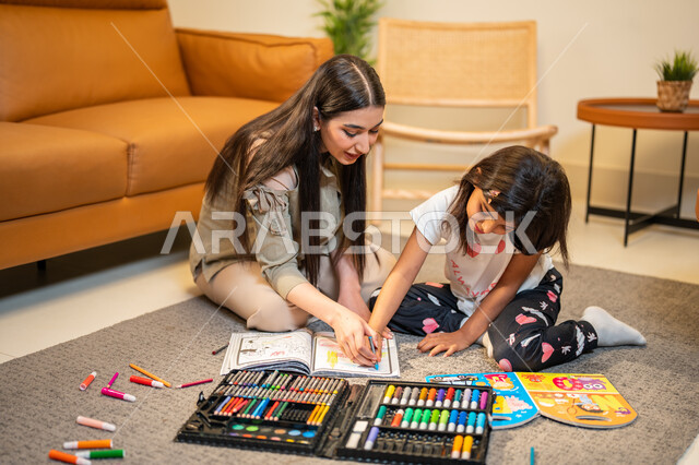 انشطة فنية ابداعية، ام عربية خليجية سعودية تقوم بتعليم ومشاركة ابنتها التلوين، حقيبة ادوات ومعدات التلوين، ايماءات وجه تدل على السعادة، مفهوم الأمومة والطفولة، رعاية وتشجيع وتطوير مهارات الأطفال، قضاء اوقات عائلية ممتعة