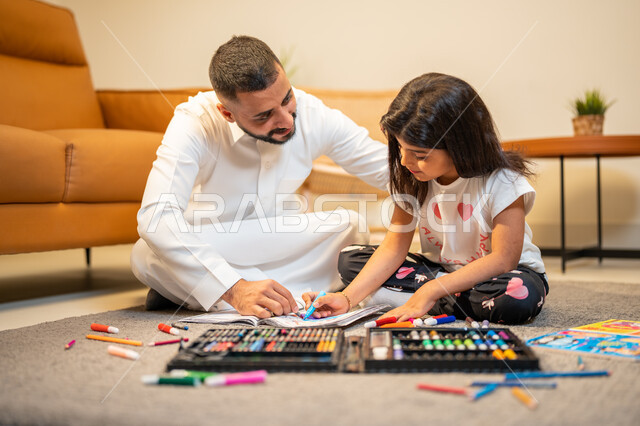 Spending fun family times, caring, encouraging and developing the skills of children, a Saudi Arabian Gulf father who teaches and shares his daughter with coloring, coloring tools and equipment, learning, creativity and developing skills, the game of colo