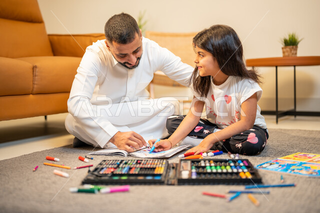 ادوات ومعدات التلوين، اب عربي خليجي سعودي يقوم بتعليم ومشاركة ابنته التلوين، رعاية وتشجيع وتطوير مهارات الأطفال، التعلم والابداع وتنمية المهارات، لعبة تلوين الرسومات، قضاء اوقات عائلية ممتعة