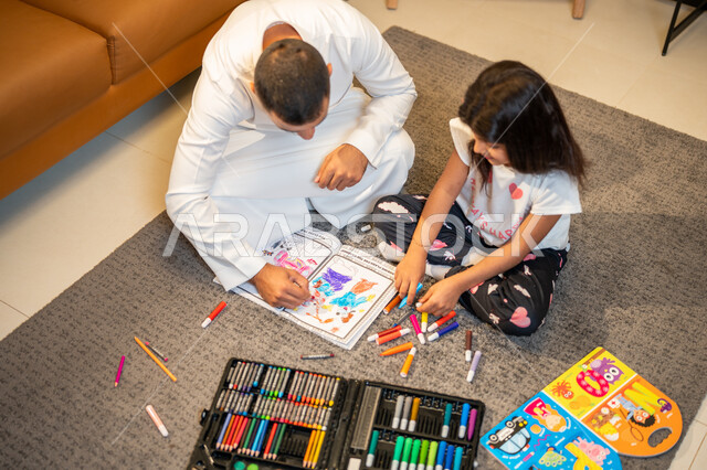التعلم والابداع وتنمية المهارات، اب عربي خليجي سعودي يقوم بتعليم ومشاركة ابنته التلوين، ادوات ومعدات التلوين، رعاية وتشجيع وتطوير مهارات الأطفال، لعبة تلوين الرسومات، قضاء اوقات عائلية ممتعة