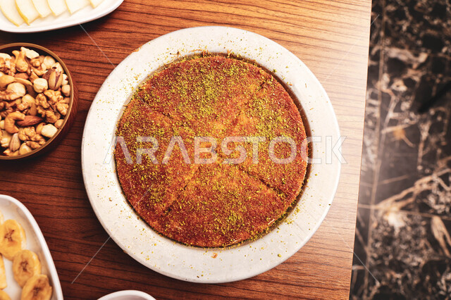 طبق من حلا الكنافة المحشوة بالقشطة والمزينة بالفستق، حلويات شرقية مشهورة، قطع الحلوى اللذيذة، سكريات وحلويات بالقطر , مطاعم ومأكولات في المملكة العربية السعودية