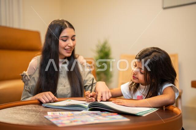 Interest in educating and supporting children, a Saudi Arabian Gulf mother who teaches her daughter, helping children in performing homework, educational activities and capacity development, learning and developing children