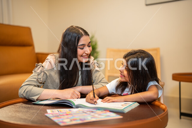 مساعدة الابناء في تأدية الواجبات المدرسية، ام عربية سعودية خليجية تقوم بتعليم ابنتها، الانشطة التعليمية وتنمة القدرات، تعلم وتطوير الابناء، الاهتمام بتعليم بالأبناء ودعمهم