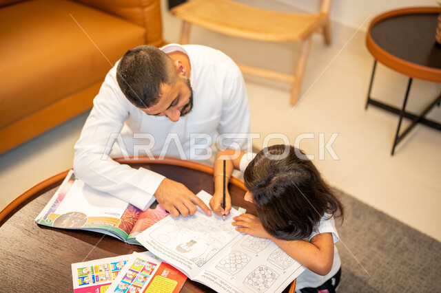 اب عربي سعودي خليجي يقوم بتعليم ابنته، مساعدة الابناء في تأدية الواجبات المدرسية، الانشطة التعليمية وتنمة القدرات، تعلم وتطوير الابناء، الاهتمام بتعليم بالأبناء ودعمهم