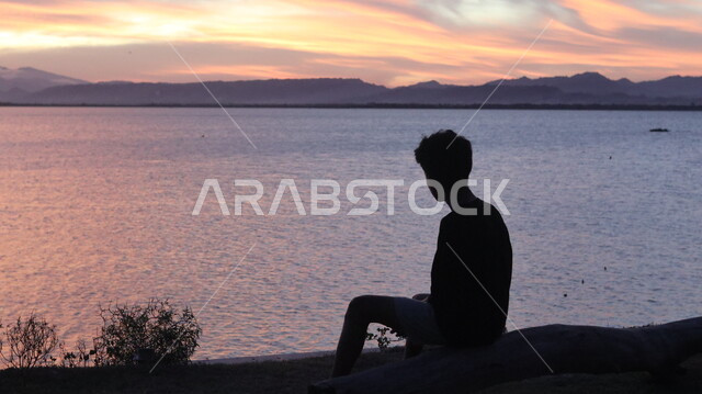 الاسترخاء والتأمل , صورة ظلية من الخلف لشاب يقف أمام بحيرة مائية , السماء والمناظر الطبيعية , منظر غروب الشمس , خلفية الطبيعة , سوليليت .