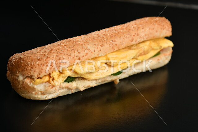 وجبة فطور عربية صحية خفيفة, صورة مقربة لساندوتش البيض الاومليت مع الخضار , مطاعم المأكولات السريعة, خلفية سوداء.