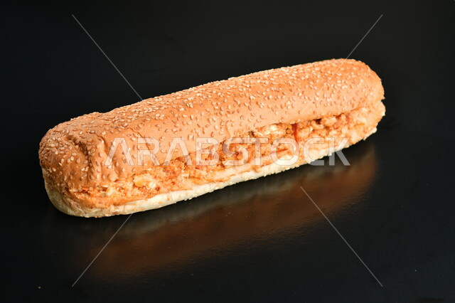 وجبة غداء خفيفة, صورة مقربة لساندويتش الدجاج المتبل الشهي مع الصلصة, مطاعم المأكولات السريعة, خلفية سوداء.