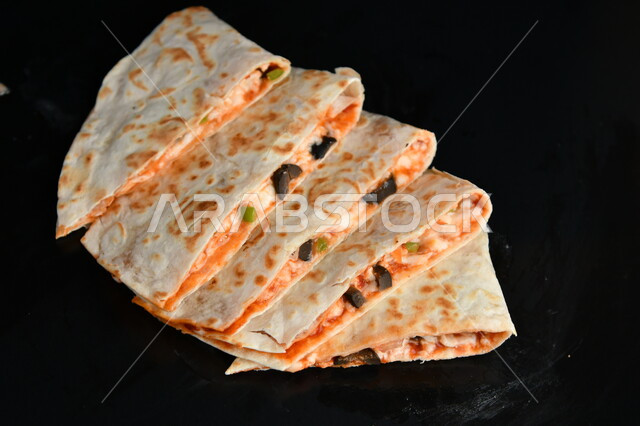 خبز التورتيلا المقطع المحشو بالدجاج والجبن و الخضار الشهية, مطاعم المأكولات السريعة, وجبة غداء و عشاء خفيفة, خلفية سوداء.