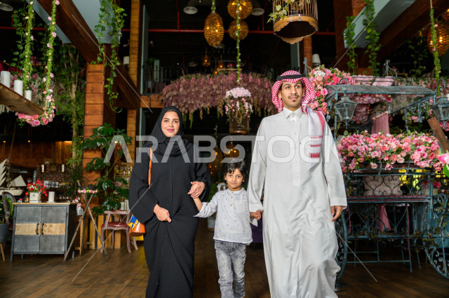 صورة من الأمام لعائلة عربية خليجية سعودية تقوم بالدخول الى المطعم ، قضاء وقتا ممتعا في المطعم ، قضاء أوقات عائلية ترفيهية ، قضاء العطلة مع العائلة ، جلسات فريدة و مميزة ، مطاعم و كافيهات في السعودية