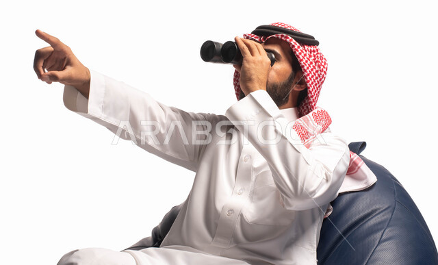 حب الاستكشاف والمغامرة، رؤية الاشياء البعيدة عبر المنظار، بورتريه مقرب من الخلف لرجل عربي خليجي سعودي يرتدي الزي التقليدي يجلس على كرسي مريح وينظر من خلال منظار الرؤية, التخطيط المستقبلي للأهداف و الطموحات، خلفية بيضاء