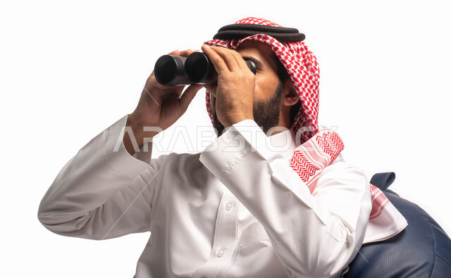 رؤية الاشياء البعيدة عبر المنظار، حب الاستكشاف والمغامرة، بورتريه مقرب من الخلف لرجل عربي خليجي سعودي يجلس على كرسي مريح وينظر من خلال منظار الرؤية, التخطيط المستقبلي للأهداف و الطموحات، خلفية بيضاء
