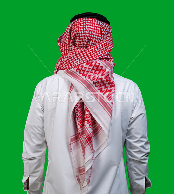 الاهتمام بالمظهر الخارجي، بورتريه من الخلف لشاب عربي سعودي خليجي يرتدي الشماغ و الثوب السعودي التقليدي يقف بإستقامة, ايماءات جسد تدل على الثقة و القوة, كروما، خلفية خضراء.