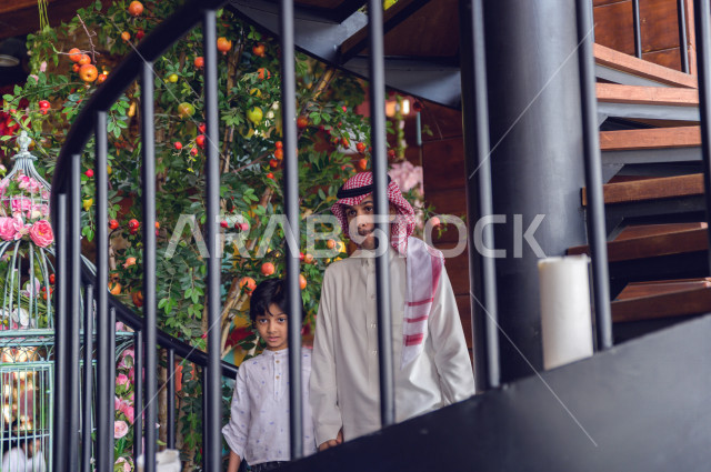 A Saudi Arabian Gulf family climbing the restaurant stairs, spending quality time inside the restaurant, enjoying and entertaining on vacation, family atmosphere, Saudi restaurants and cafes