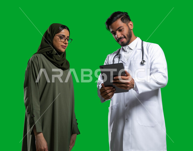 توضيح و شرح طريقة العلاج عبر جهاز التابلت, وصف الحالة المرضية و تقديم الاستشارات الطبية، بورتريه لطبيب عربي خليجي سعودي يرتدي المعطف و السماعة الطبية يتحدث مع المريضة, مفهوم الطب المنزلي, إعطاء العلاج المناسب للمرضى, كروما، خلفية خضراء. 