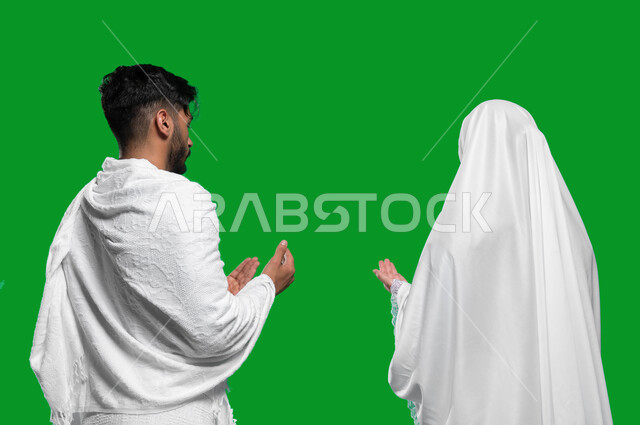 المحافظة على الصلوات و الدعاء وطلب المغفرة من الله تعالى, فضل أداء العمرة في شهر رمضان المبارك, تلبية نداء الله الى الحج و العمرة،  بورتريه مقرب من الخلف لزوجان عربيان خليحيان سعوديان يرتديان ثياب الإحرام، اسلاميات وعبادة، كروما, خلفية خضراء.